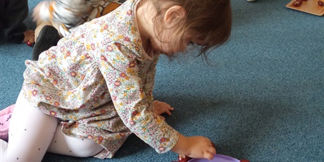 Powiększ grafikę: Dziewczynka na dywanie liczy kasztany